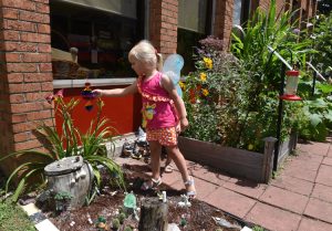 Amaris Geer, 4, touches one of her favorite things in the fairy garden at Mount Pleasant Library, it's part of the Story Garden. She said of the whirlygig, "sometimes I really, really, really like that thing over there."