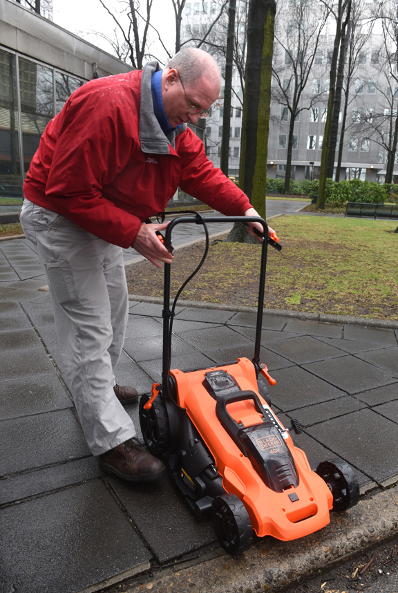 Andy Amrhein, owner of Evey True Value Hardware in Bethel Park folds up the handle of a Black and Decker rechargable electric lawnmower. It's lightweight, powerful and quiet.